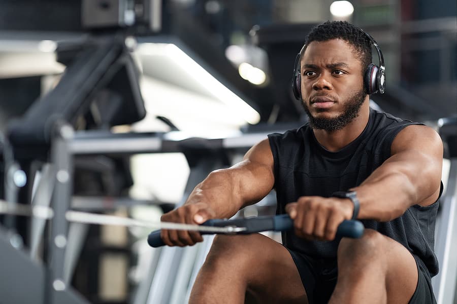 Black man rowing hard for high-intensity interval training