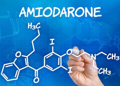 Hand with pen drawing the chemical formula of Amiodarone