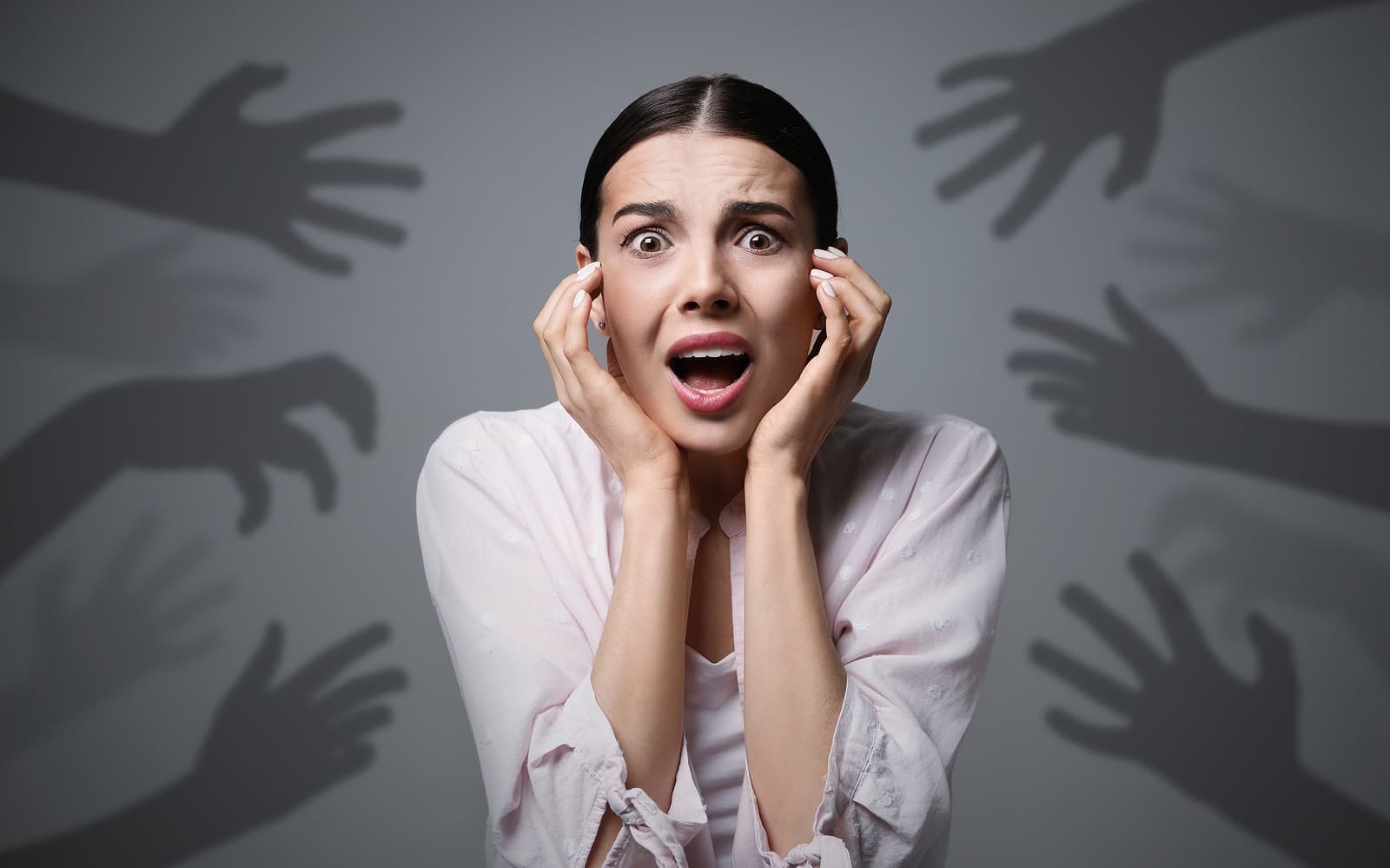 shadow hands reach to anxious woman
