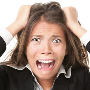 Stress. Woman stressed is going crazy pulling her hair in frustration. Close-up of young businesswoman on white.

