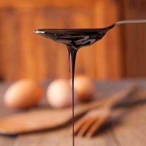 Blackstrap molasses for baking drizzling from a teaspoon