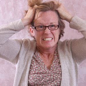 A very frustrated middle-aged woman pulling her hair out