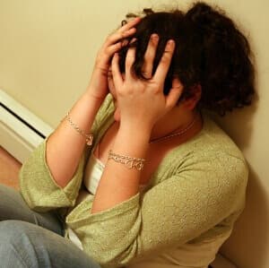 depressed teen holding her head