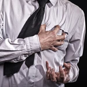 Man grabs at his heart during a heart attack