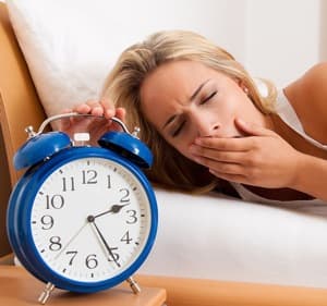 sleepy woman with alarm clock