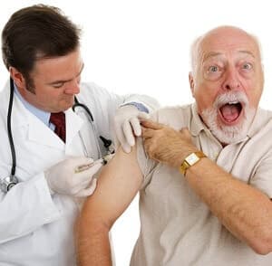 Senior man at the doctor&#8217;s office, surprised by a painful injection. Isolated on white.
