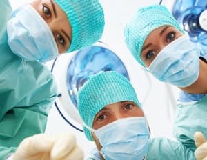 close up of three doctors faces wearing surgical scrubs and masks