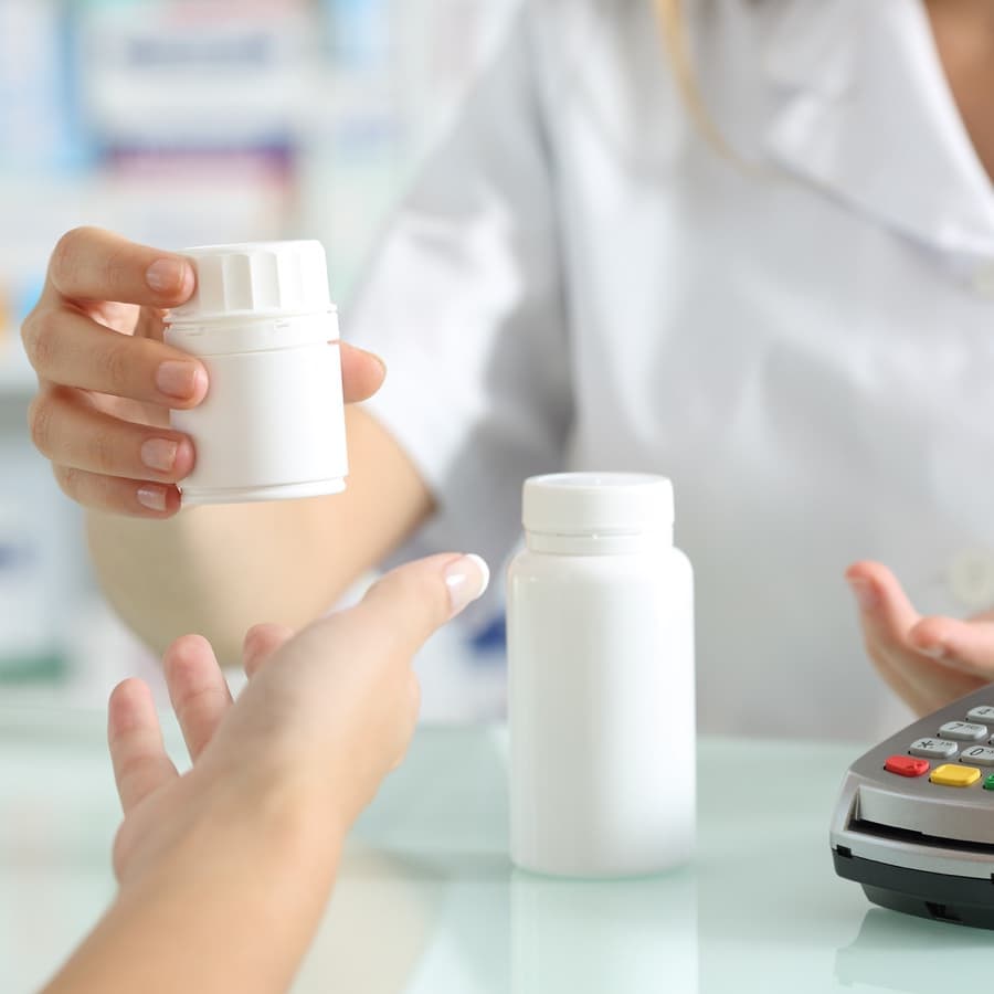 pharmacist hands selling medicines to a customer on a pharmacy desk; simple job description; refill prescriptions