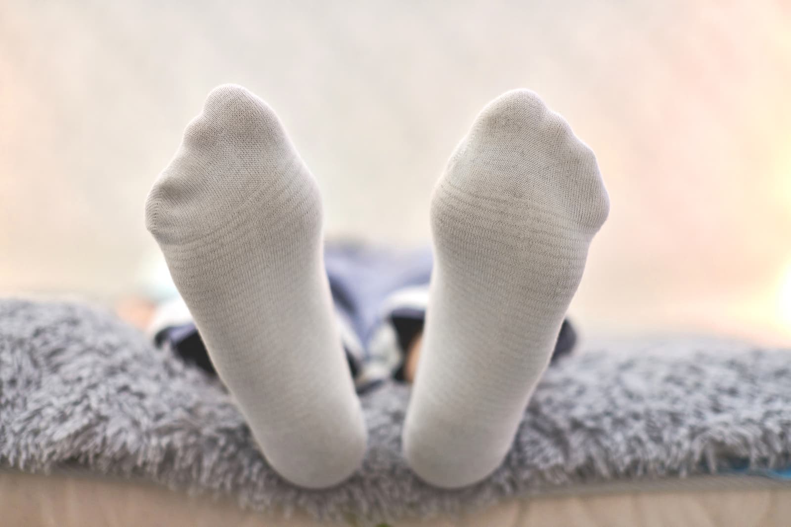 view of soles of feet clad in socks to cover Vicks on feet