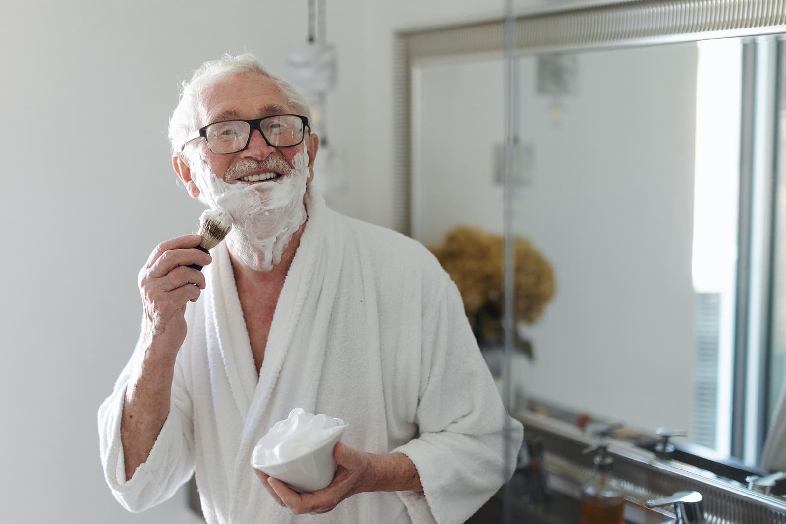 older man shaving his face
