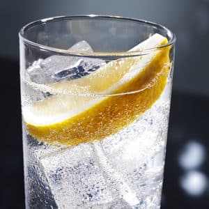 a glass of tonic water with a slice of lemon