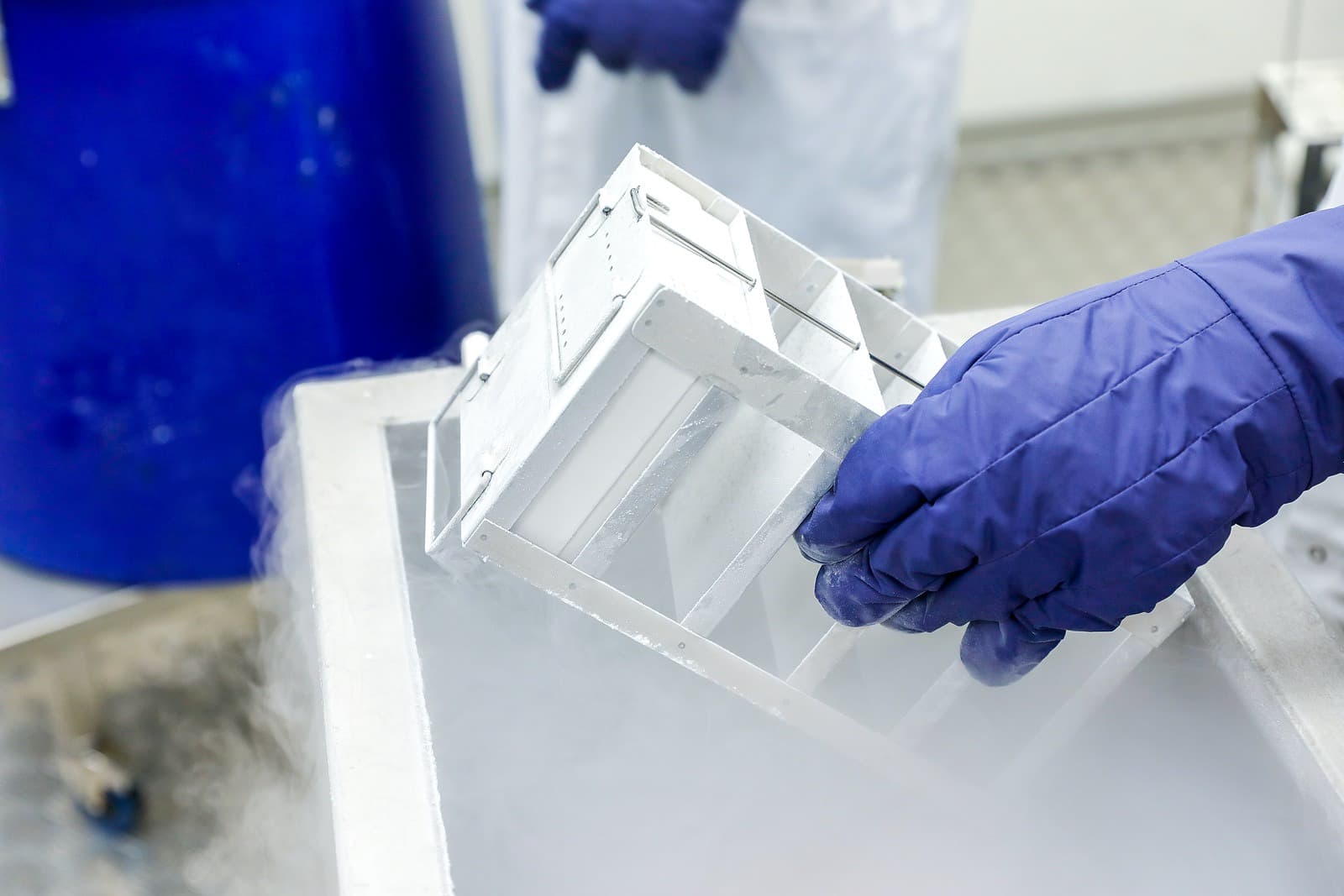 Hand in glove with vaccines going into freezer