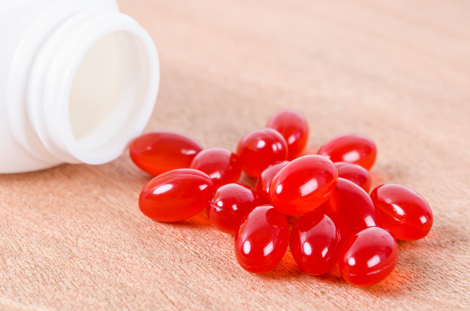 red capsules of CoQ10 spill out of bottle