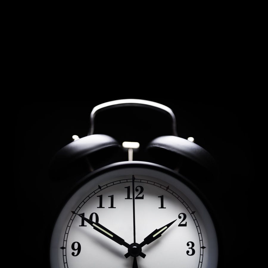 Alarm clock in the middle of the night isolated on black concept for insomnia or sleepless night
