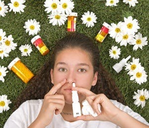Girl on grass with medicines for allergies
