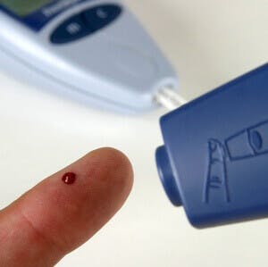 a person checking their blood sugar with a pin prick device
