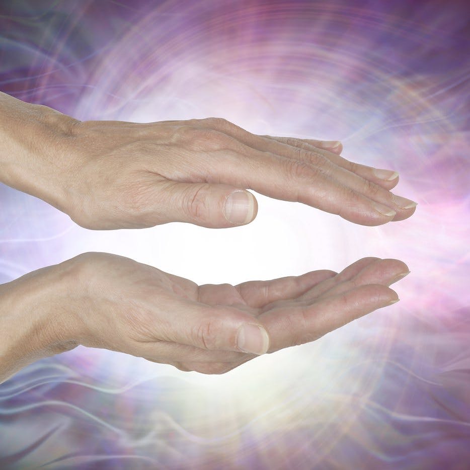Channeling Vortex healing energy  &#8211; female hands held parallel with a white vortex energy formation and pink blue ethereal energy field  background
