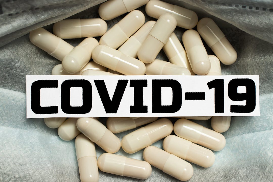 COVID-19 Wuhan Coronovirus. Tablets capsules for the treatment of Wuhan coronovirus. A medicine to treat a viral infection. Pneumonia disease caused by COVID-19. Pills in a medical mask.
