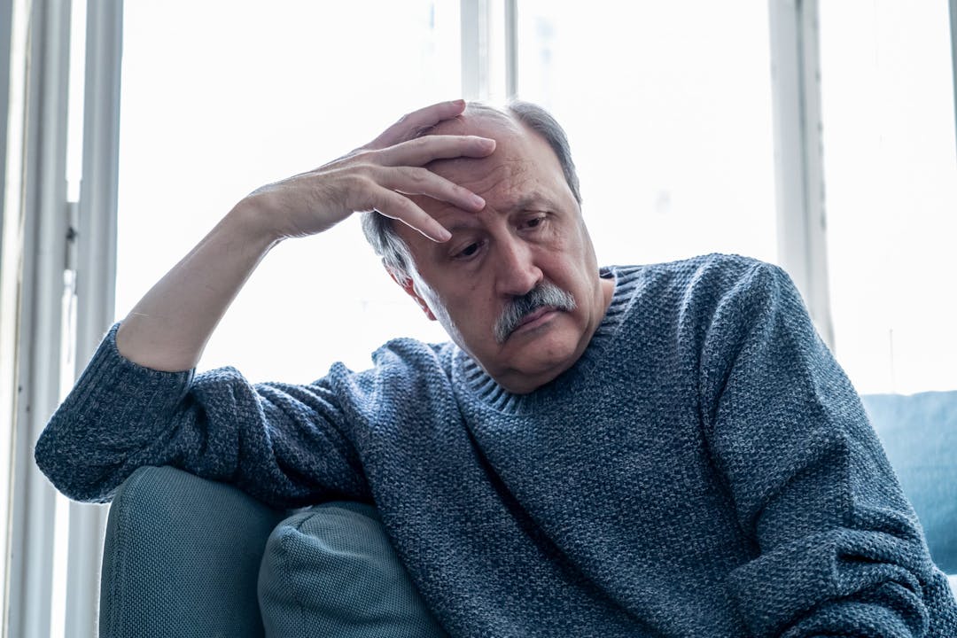 Portrait of older adult senior man in pain with sad and exhausted face in human emotions facial expression retirement and depression concept isolated on neutral background.
