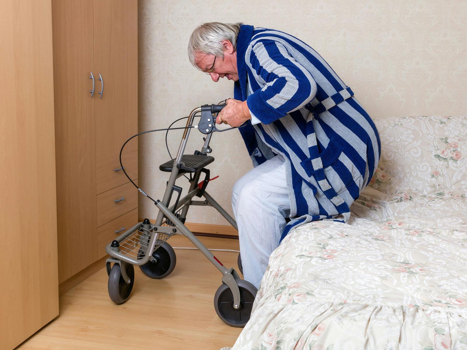 Elderly grandfather in nursing home using a rollator in his pajama
