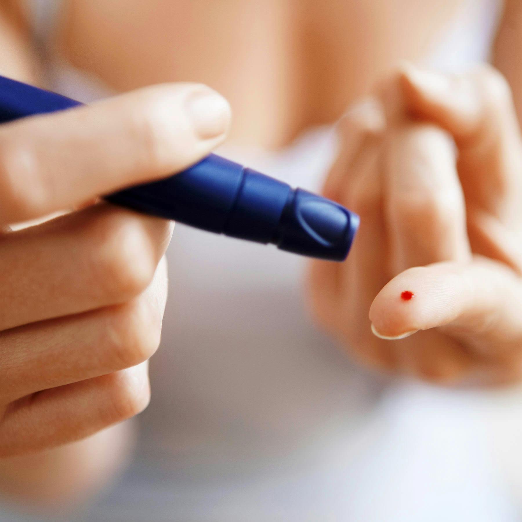Taking a blood sugar reading with a lancet, diabetes risk