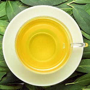 cup of green tea on top of green tea leaves