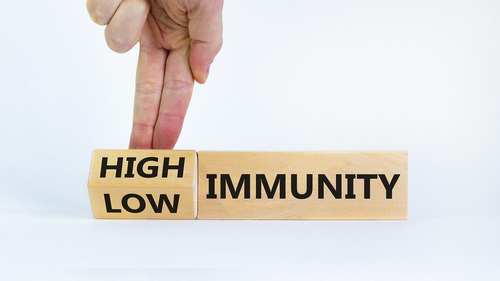 High or low immunity symbol. Doctor turns a block and changes words &#8216;low immunity&#8217; to &#8216;high immunity&#8217;. Beautiful white background. Medical, high or low immunity concept. Copy space.
