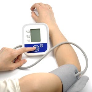 Female hands with blood-pressure meter isolated over white
