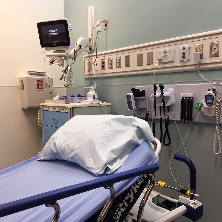 a hospital room with bed and monitor