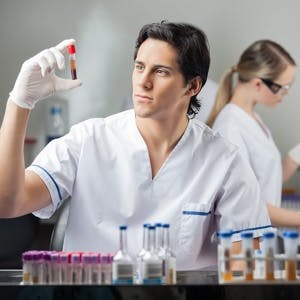 Male technician analyzing blood sample in medical laboratory
