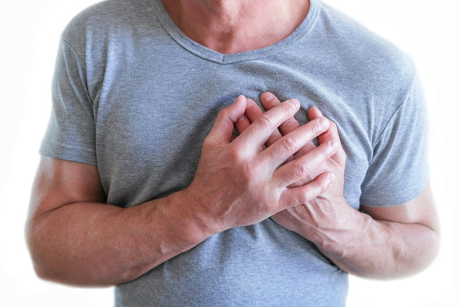 Man clutching his chest because of heart pain
