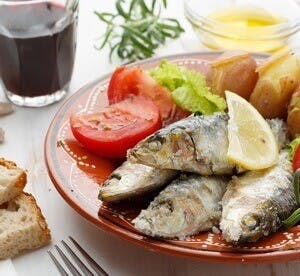 a plate with fish and veggies, typical mediterranean diet