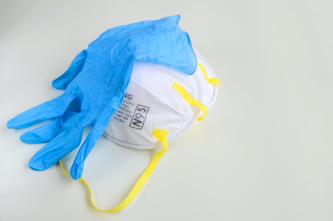 N95 respirator with medical glove on grey background for covid-19 Coronavirus prevention concept.
