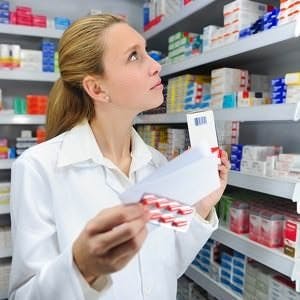 a pharmacist at work behind the counter of a pharmacy