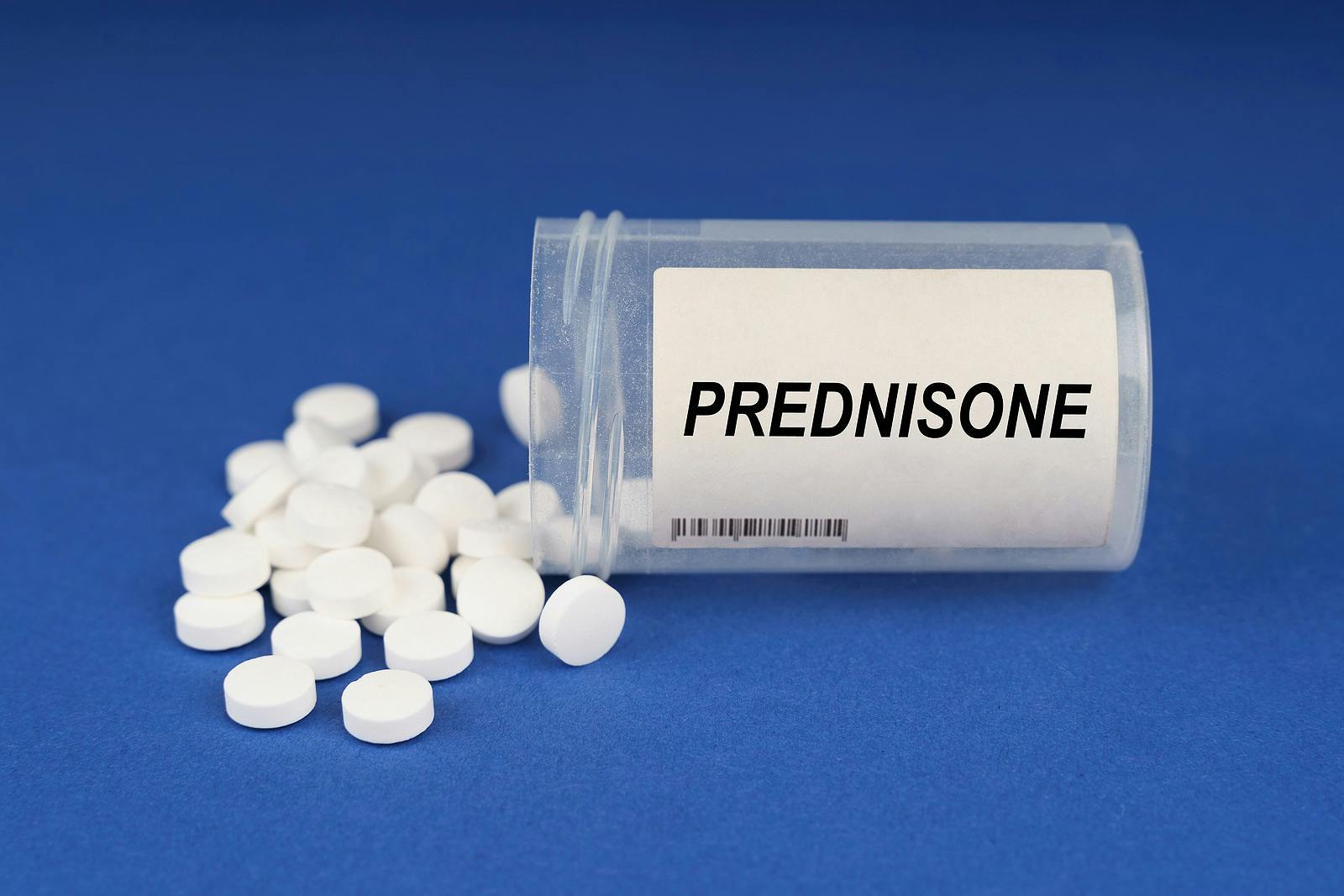The concept of pharmacology and health. On a blue surface are pills and a dusty jar with the inscription &#8211; Prednisone
