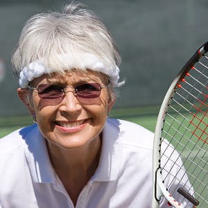 Senior woman playing tennis, portrait
