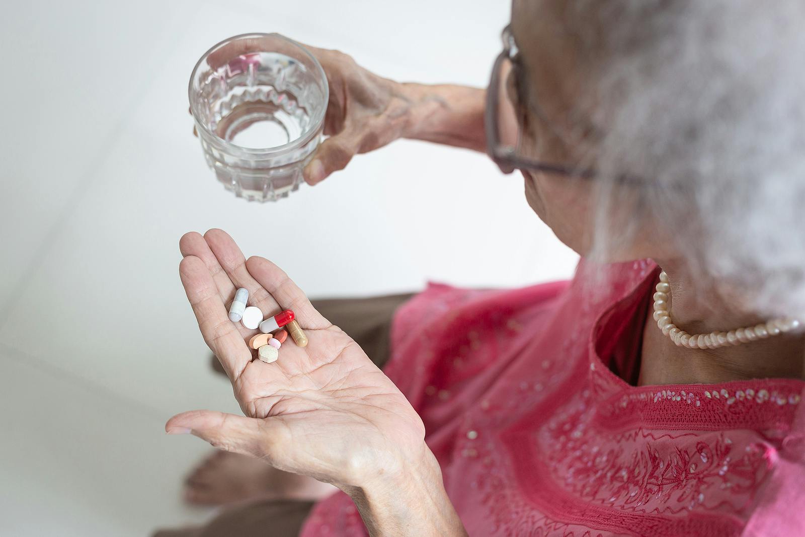 Older woman takes pills, experiences adverse drug reactions