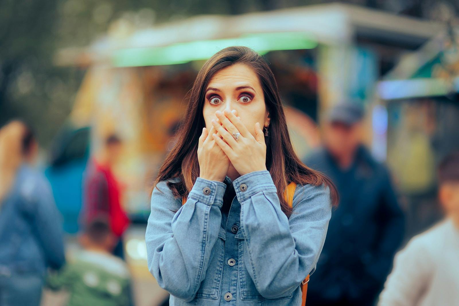 Woman feeling Sick Covering her Mouth at Local Funfair
