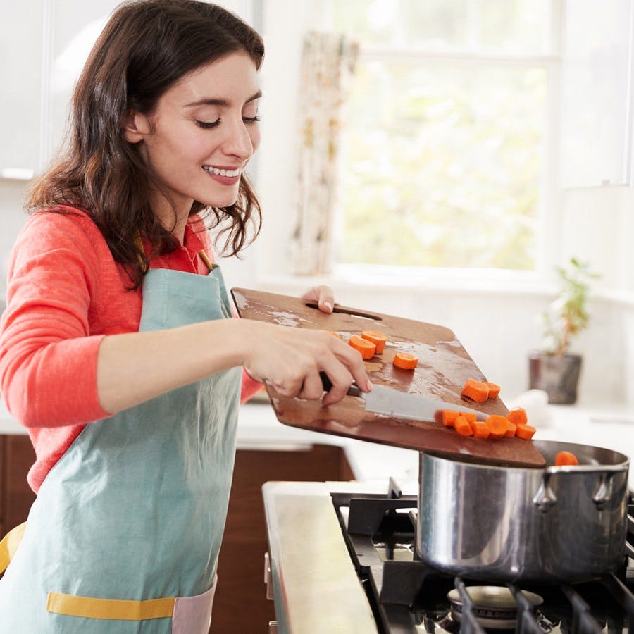 Woman cooking carrots in kitchen for Jewish passover meal
