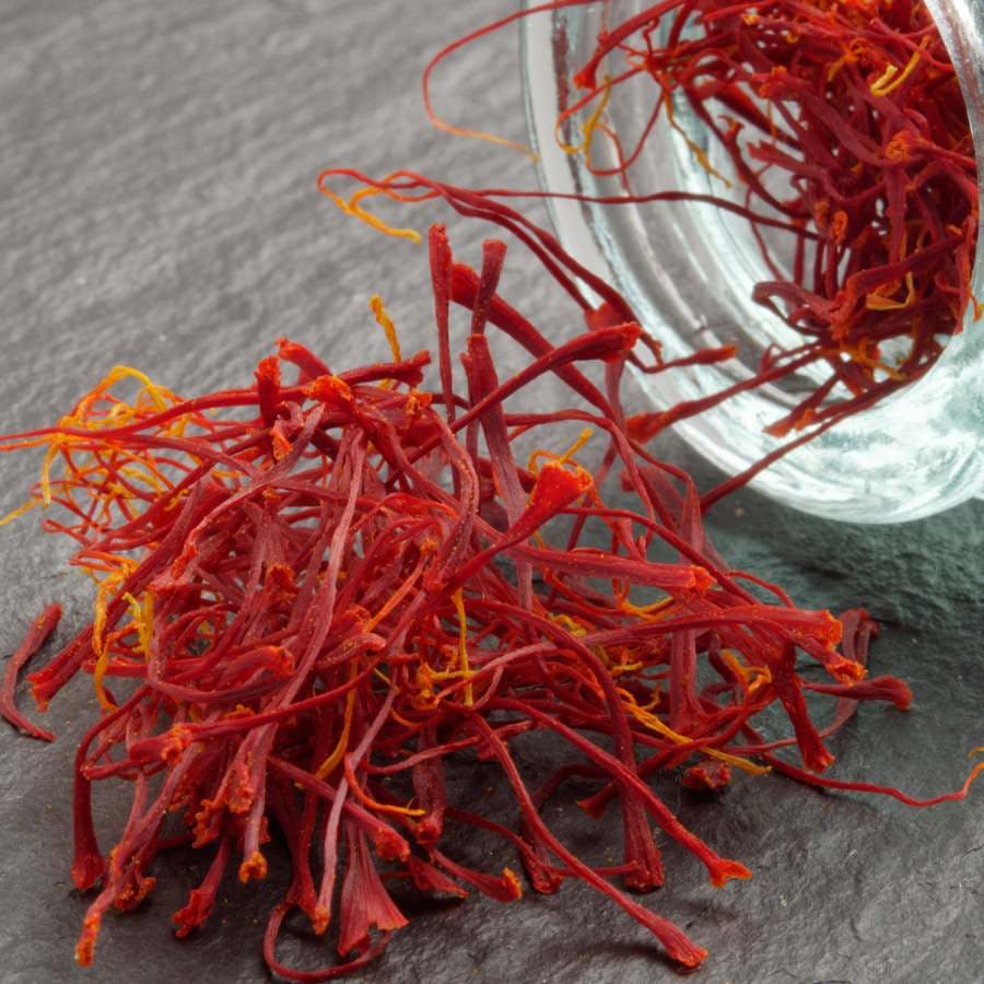 Dried saffron stigmas on slate surface closeup
