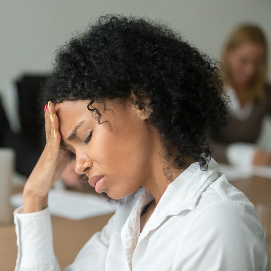 African american businesswoman feeling unwell suffering from headache migraine touching forehead at team meeting, upset black woman employee frustrated by business problem or work stress, head shot
