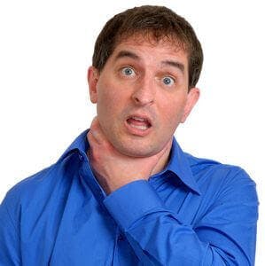 Man in blue dress shirt choking himself.
