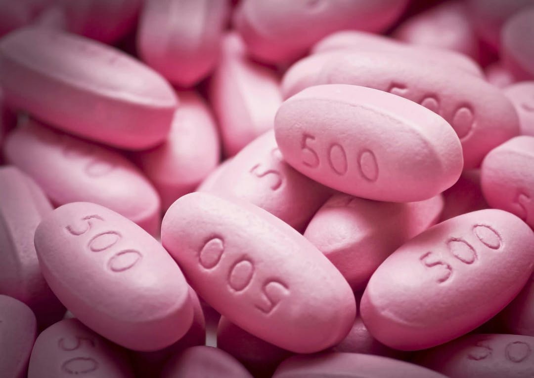Close-up of many pink 500 milligrams pills.

