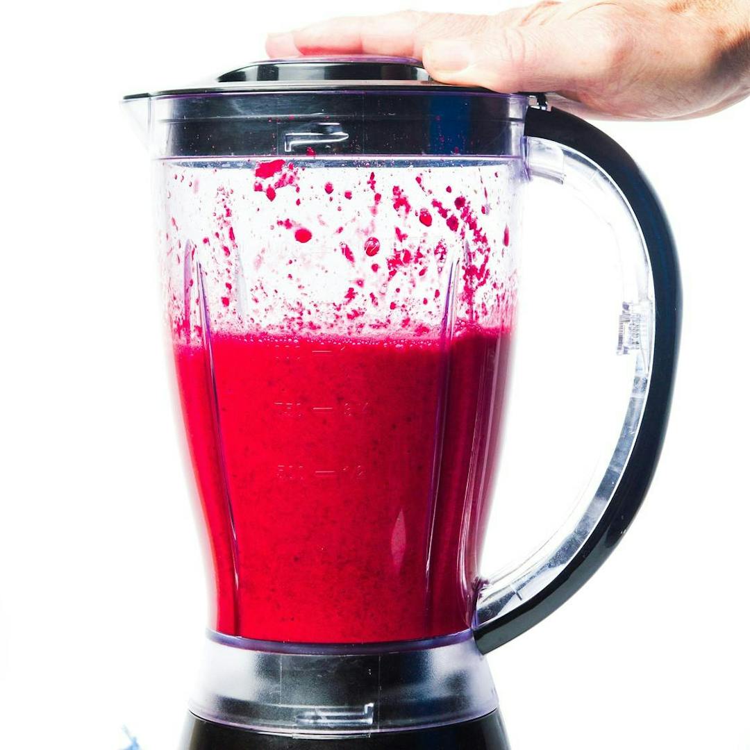 Healthy beetroot smoothie mixing in a blender isolated
