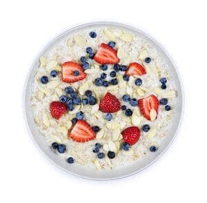 Bowl of hot oatmeal breakfast cereal with fresh berries from above
