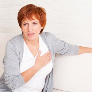 Cardiac pain. Mature woman holds her heart
