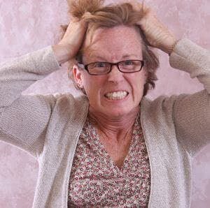A very frustrated middle-aged woman pulling her hair out
