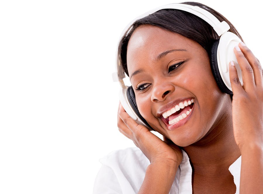 Happy woman listening to music with headphones &#8211; isolated over white
