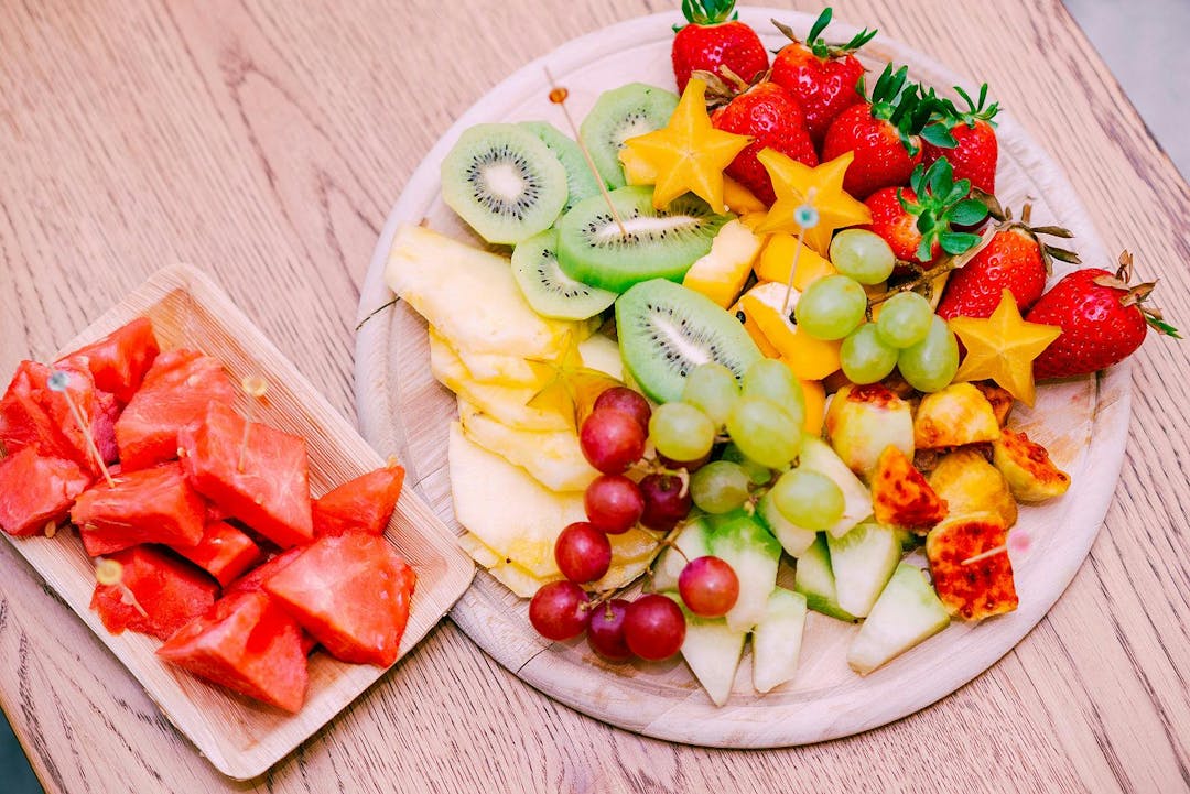 Raw Organic Fruit Platter With Berries, Melons, Kiwi, Mango, Pineapple, Carambola, Watermelon, Prickly Pear, Strawberry On The Wooden Board, On The Table, Top View, Selective Focus.
