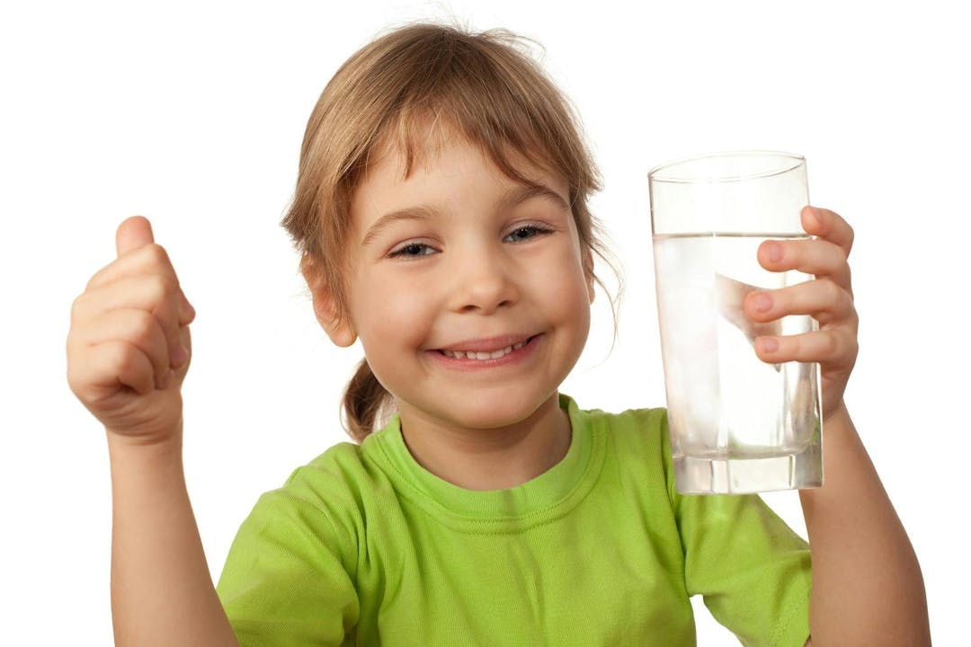 Small child drink water from glass container
